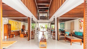 A spacious lobby with a central table, seating areas, and a view of the outdoors. - Javana Royal Villas (Keroboken Kelod)
