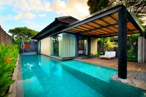 A modern poolside area with a clear pool, a covered seating area, and a view of the surrounding greenery. - Javana Royal Villas (Keroboken Kelod)