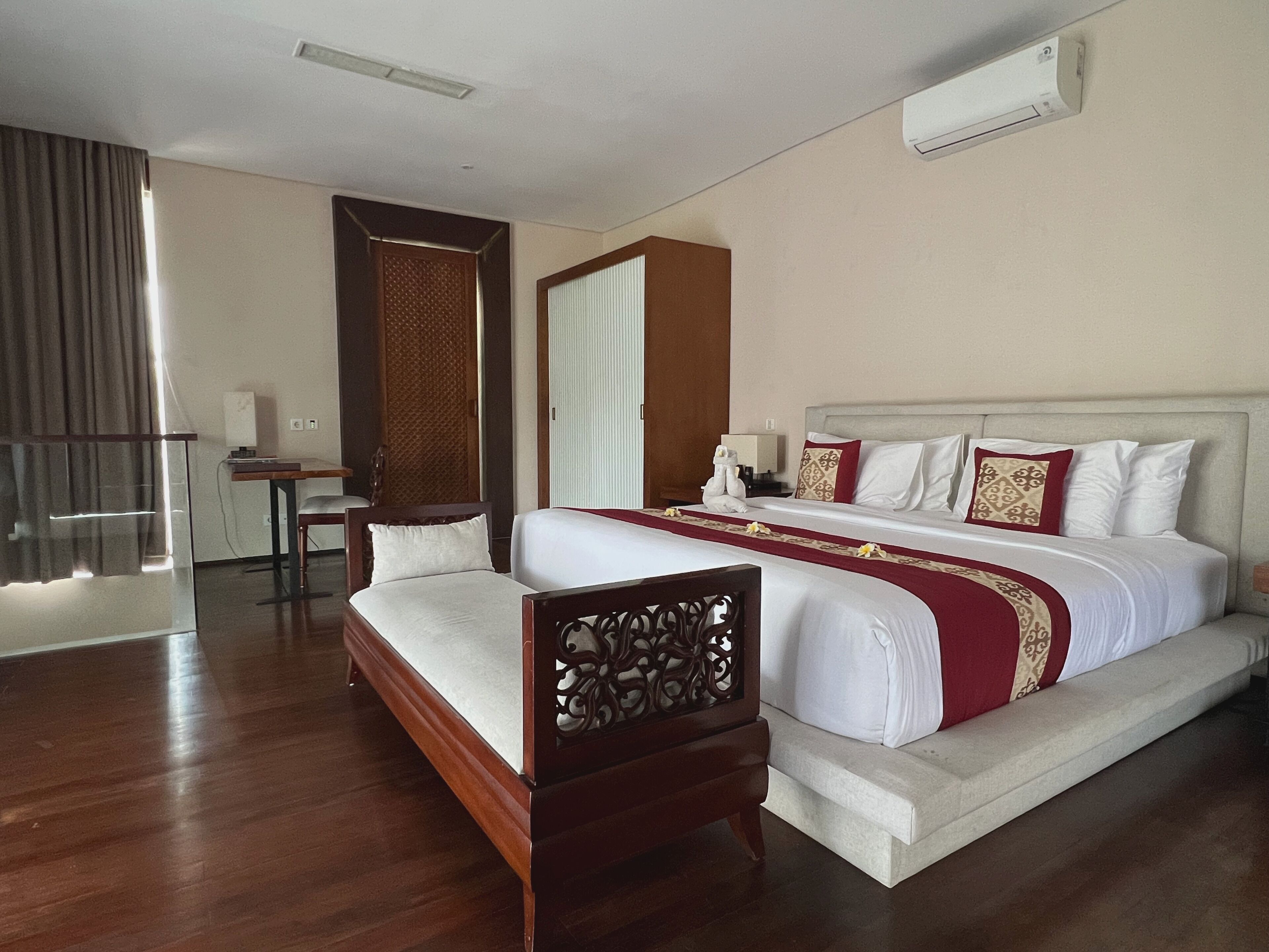 A hotel room with a large bed, a desk, and a chair.