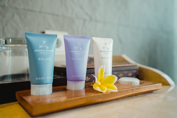 Três frascos de produtos para o corpo da Aromatherapy Associates sobre uma bandeja de madeira.