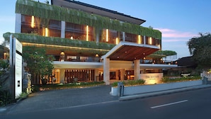A modern hotel with a two-story structure, a covered entrance, and a sign indicating it is The Magati. - The Magani Hotel and Spa (Legian)