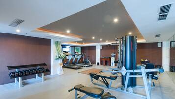 Un gimnasio con cintas de correr, pesas y máquinas de musculación.