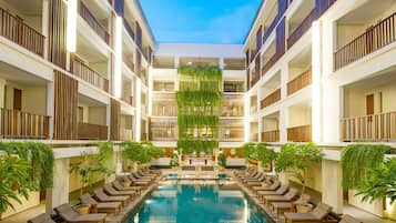 Una piscina al aire libre, sillones reclinables de piscina