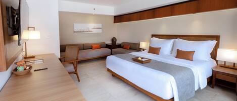A modern hotel room with a large bed, a desk, and a TV.