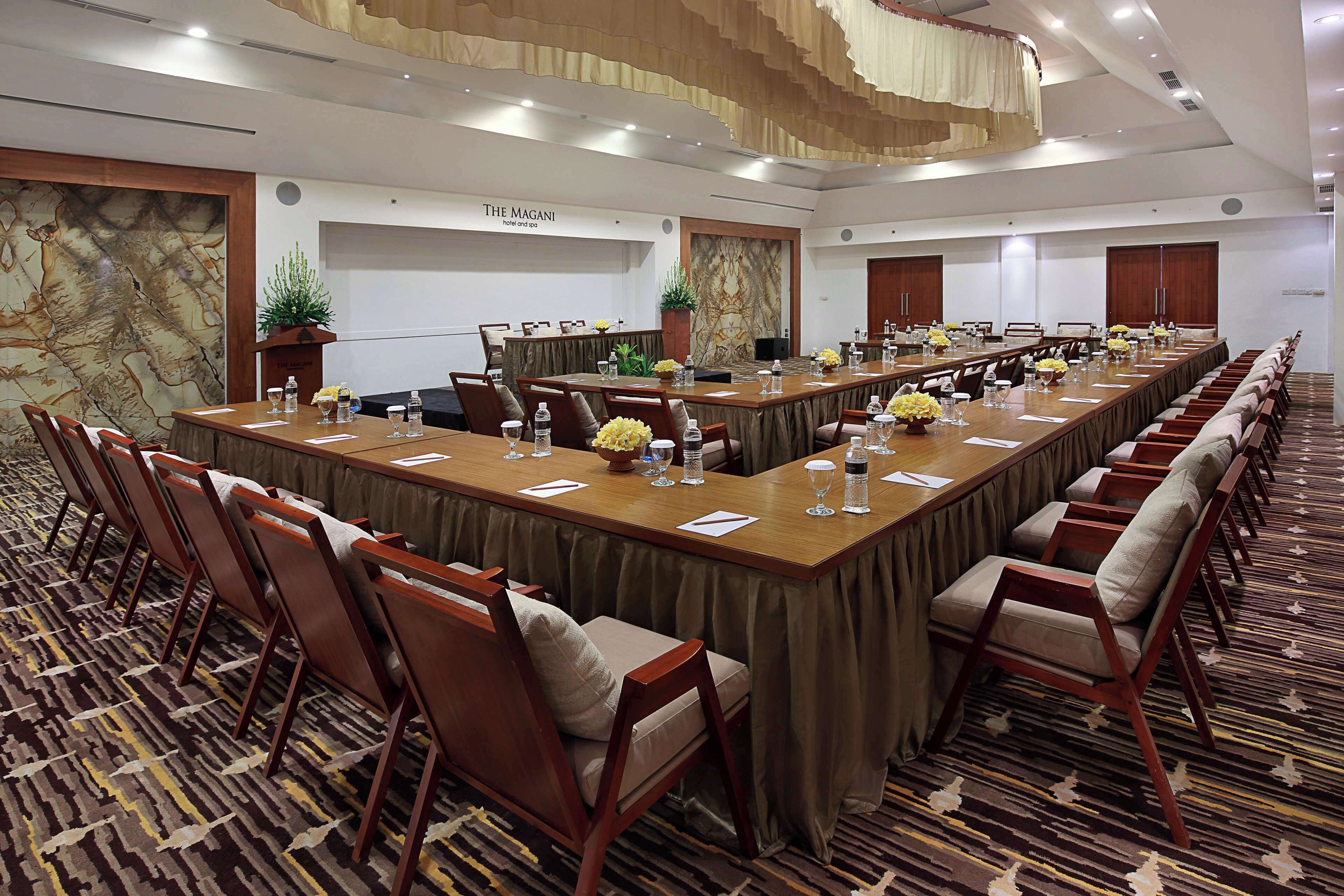 A conference room with a long table, chairs, and a projector screen.