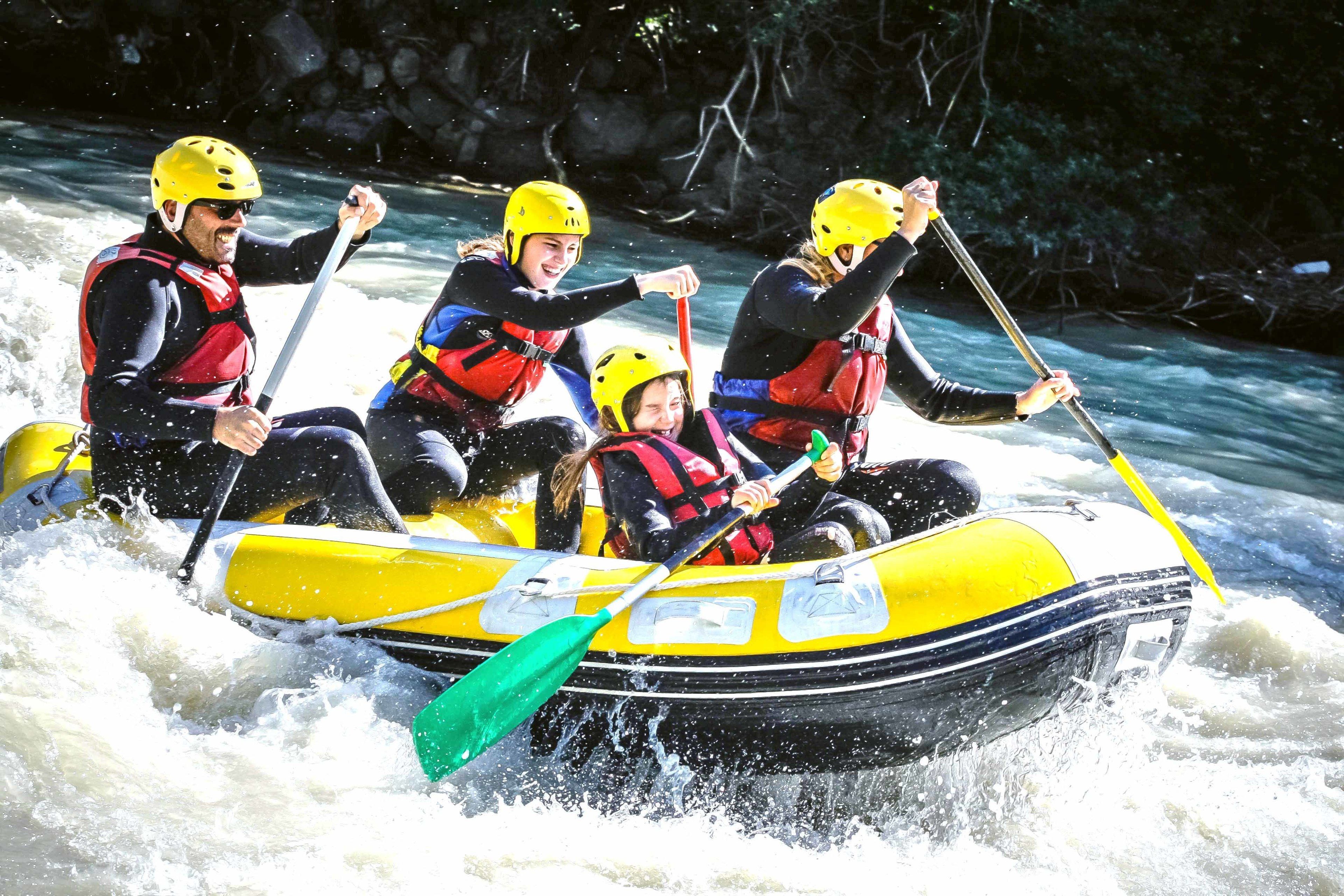 Un grupo de personas en un bote amarillo navegando por un río.