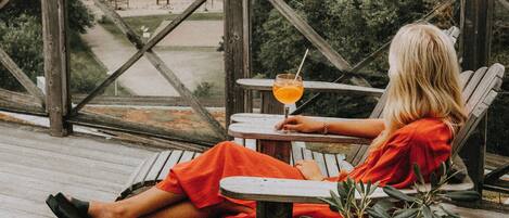 A person relaxing on a wooden deck with a view of the sea and a distant shoreline.