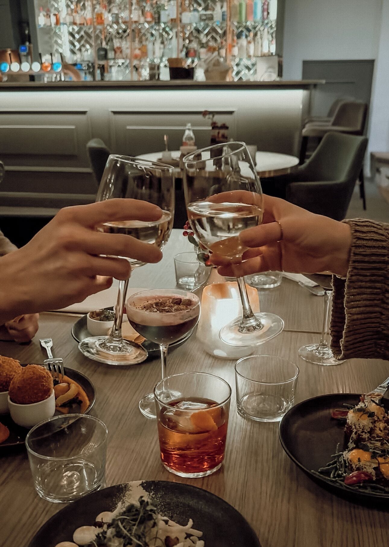 Une table à manger avec différents plats, des verres et une bougie.
