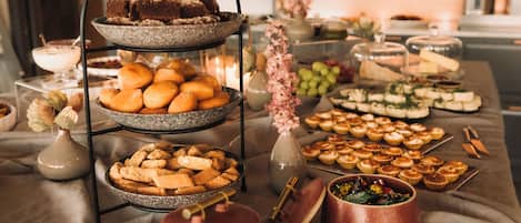 A buffet table with various food items and a tiered serving stand.