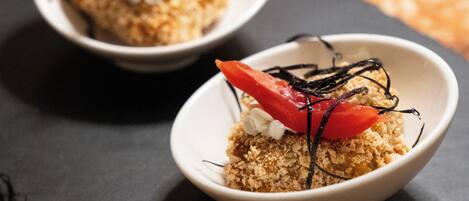 Two bowls of dessert with fruit and chocolate on a table.