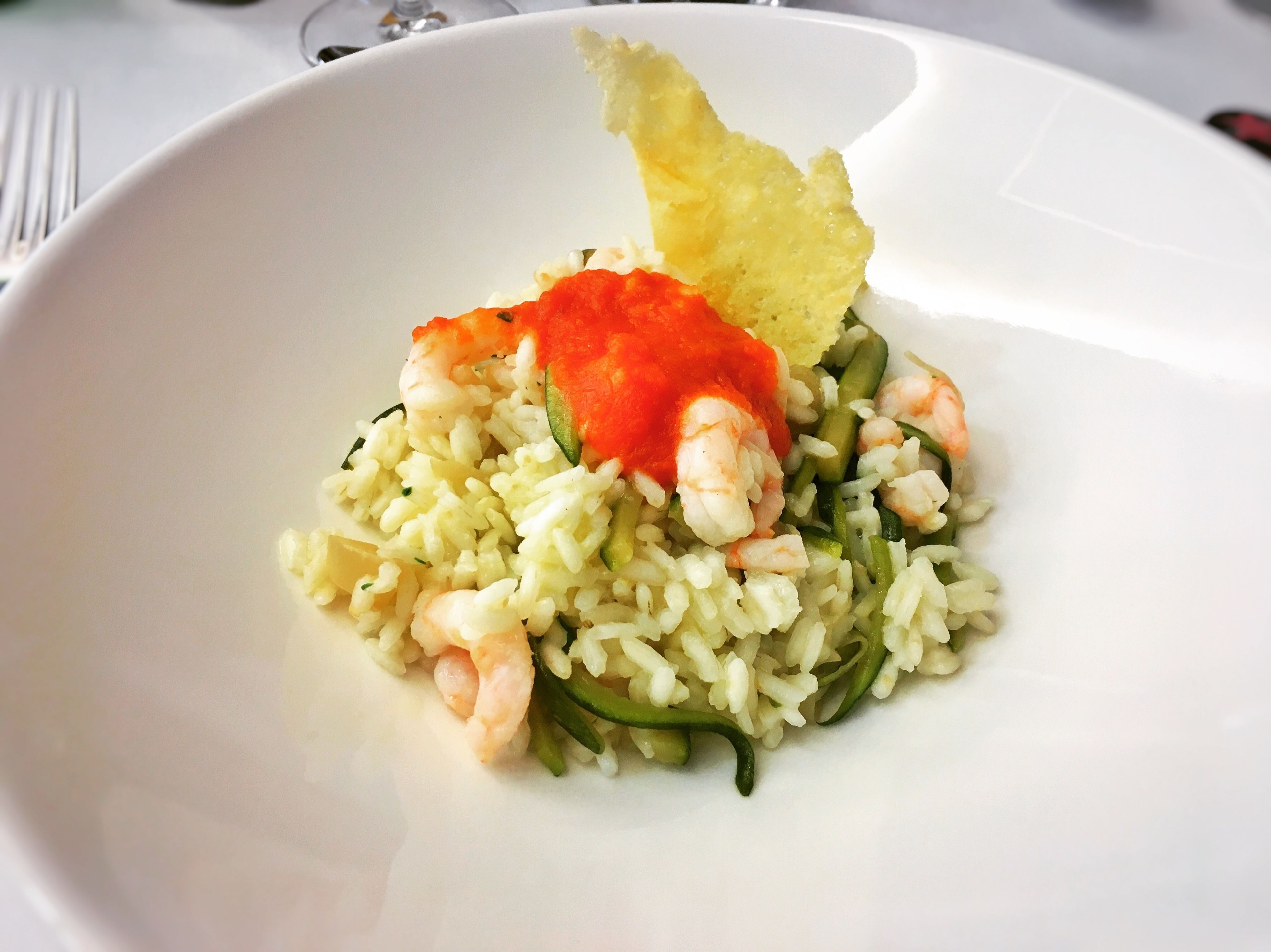 A white plate with rice, shrimp, and a piece of bread.