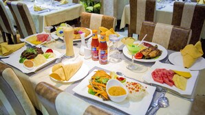 A restaurant table set with various dishes, condiments, and drinks.