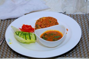 Un plato con ensalada, un guiso de arroz y un tazón de sopa.