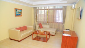 A living room with two sofas, a coffee table, and a wooden side table.
