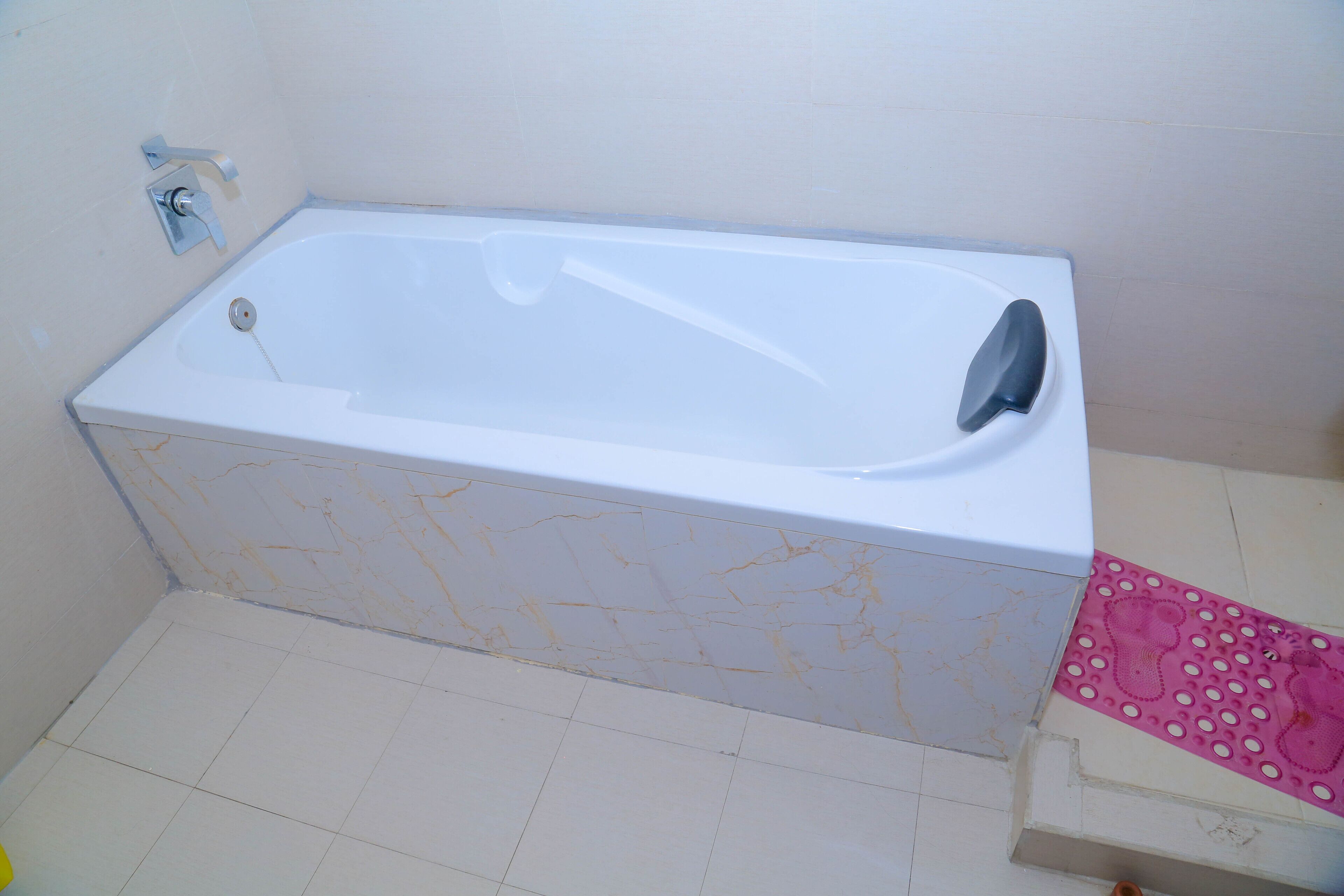 A standard white bathtub with a faucet and a shower control panel.