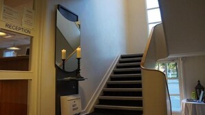 A reception area with a staircase leading to a second floor. - Danhostel Brande (Brande)