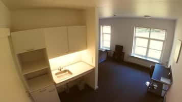 A compact kitchen with a sink, cabinets, and a window providing natural light.