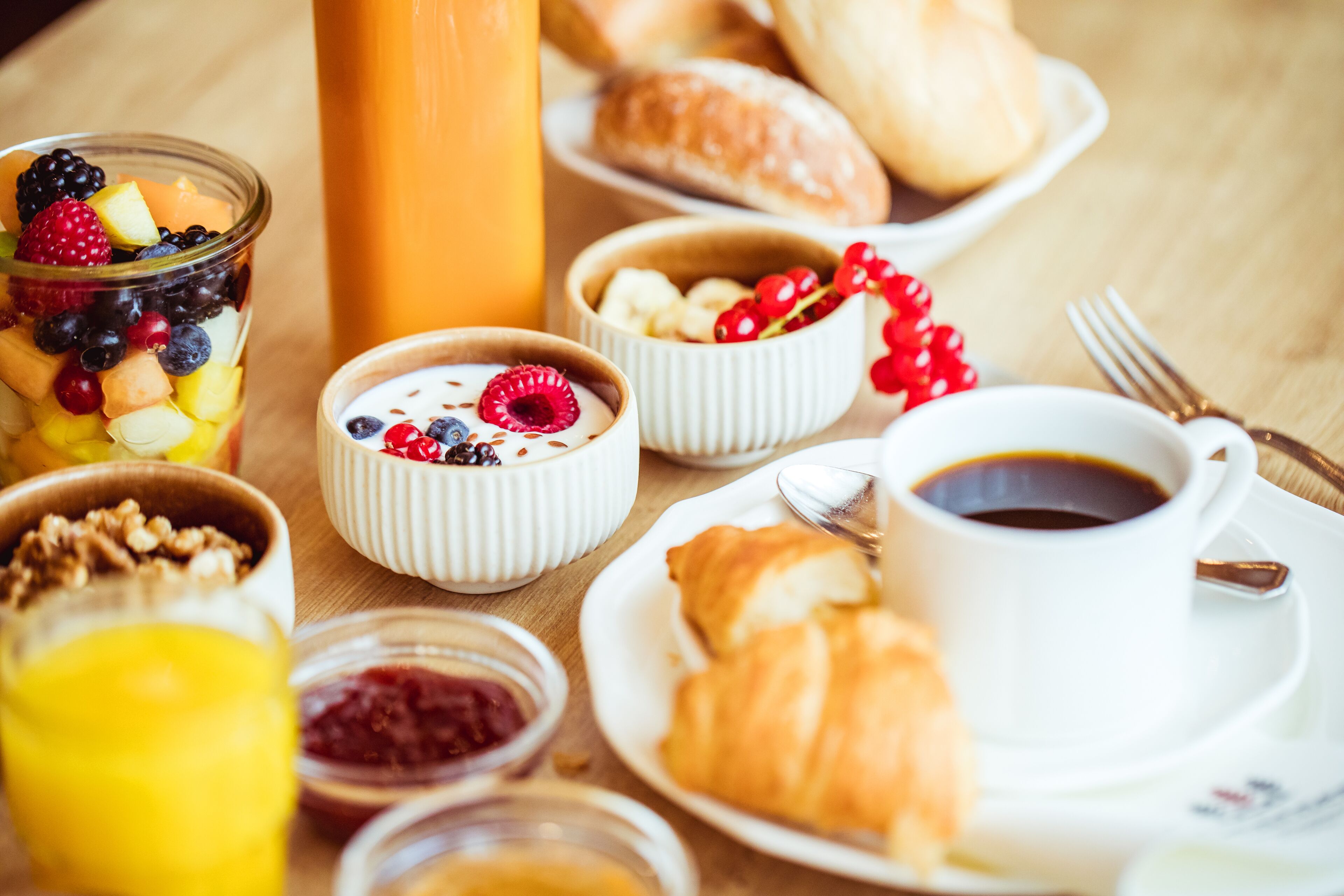 A breakfast setting with various food items and a cup of coffee.