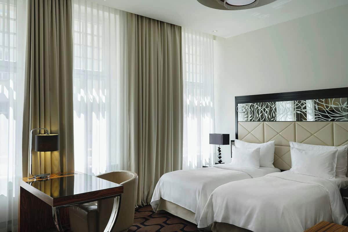 Una habitación de hotel con una cama, un escritorio y una silla.
