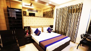 A hotel room with a large bed, a desk, and a wardrobe. - Hotel Yug Villa (New Delhi)