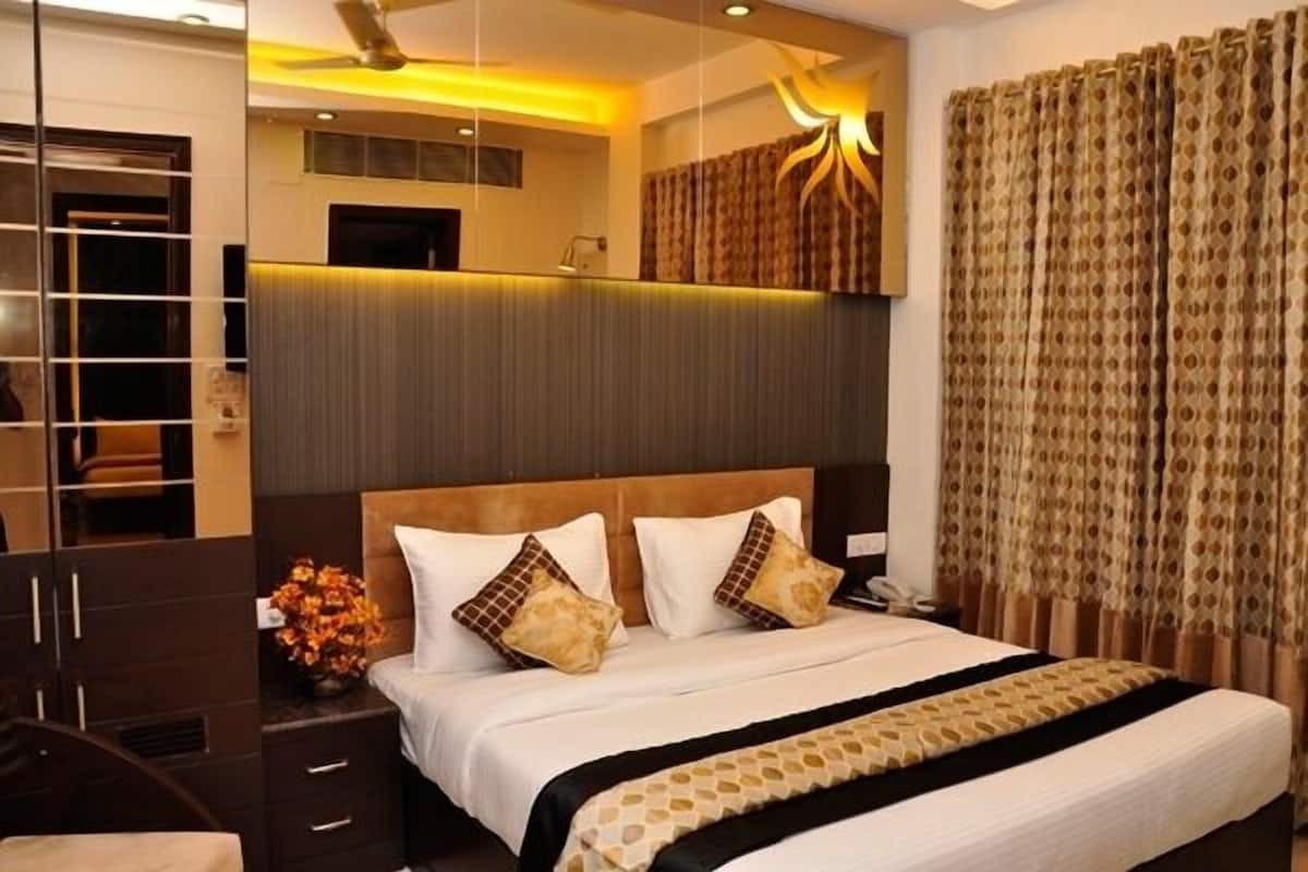 A hotel room with a bed, a desk, and a wardrobe.
