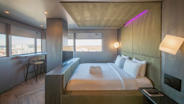 A modern hotel room with a large bed, a desk, and a view of the city. - Bloc Hotel London Gatwick Airport (Gatwick)