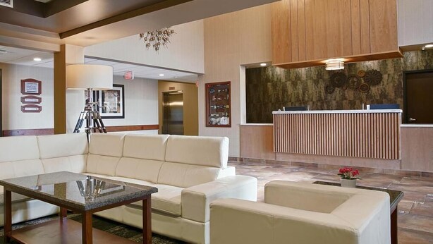 Eine Lobby mit einem weißen Sofa, einem Glastisch und einem Empfangsbereich.