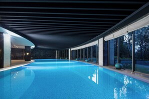 An indoor swimming pool with a dark ceiling and large windows. - Crowne Plaza Chongqing New North Zone by IHG (Chongqing)