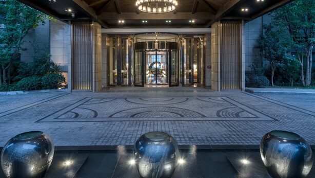 A grand entrance with a large chandelier, a central revolving door, and a tiled floor with a geometric pattern. - Crowne Plaza Chongqing New North Zone by IHG (Chongqing)