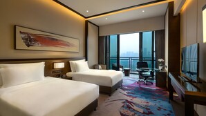 A hotel room with two beds, a desk, a chair, a TV, and a large window with a city view. - Crowne Plaza Chongqing New North Zone by IHG (Chongqing)