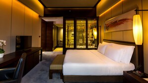 A hotel room with a bed, bedside table, TV, desk, and a bathroom visible through a partition. - Crowne Plaza Chongqing New North Zone by IHG (Chongqing)
