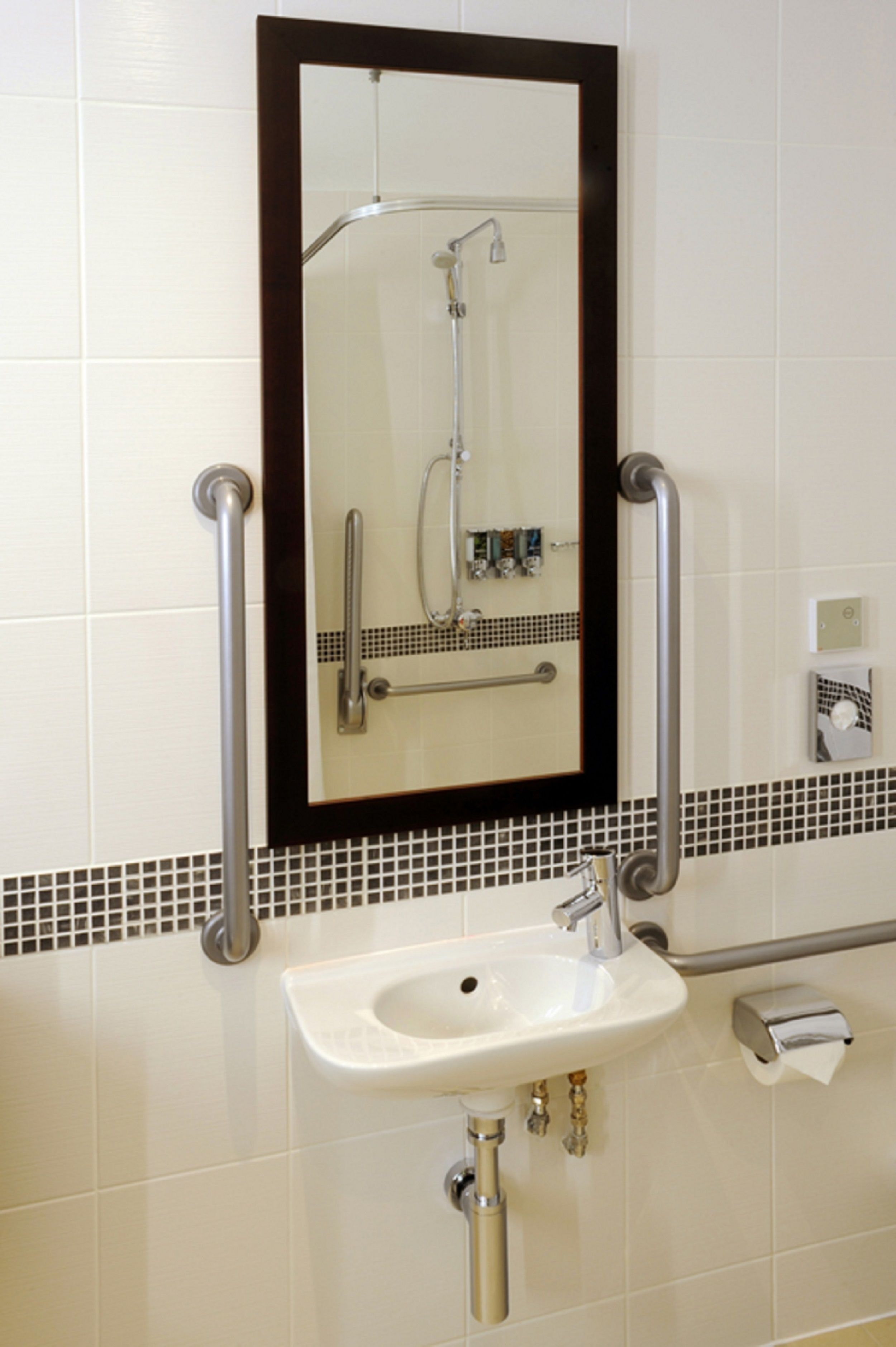 A bathroom with a white sink, a mirror, and a shower.