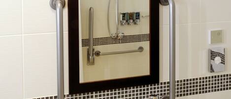 A bathroom with a white sink, a mirror, and a shower.