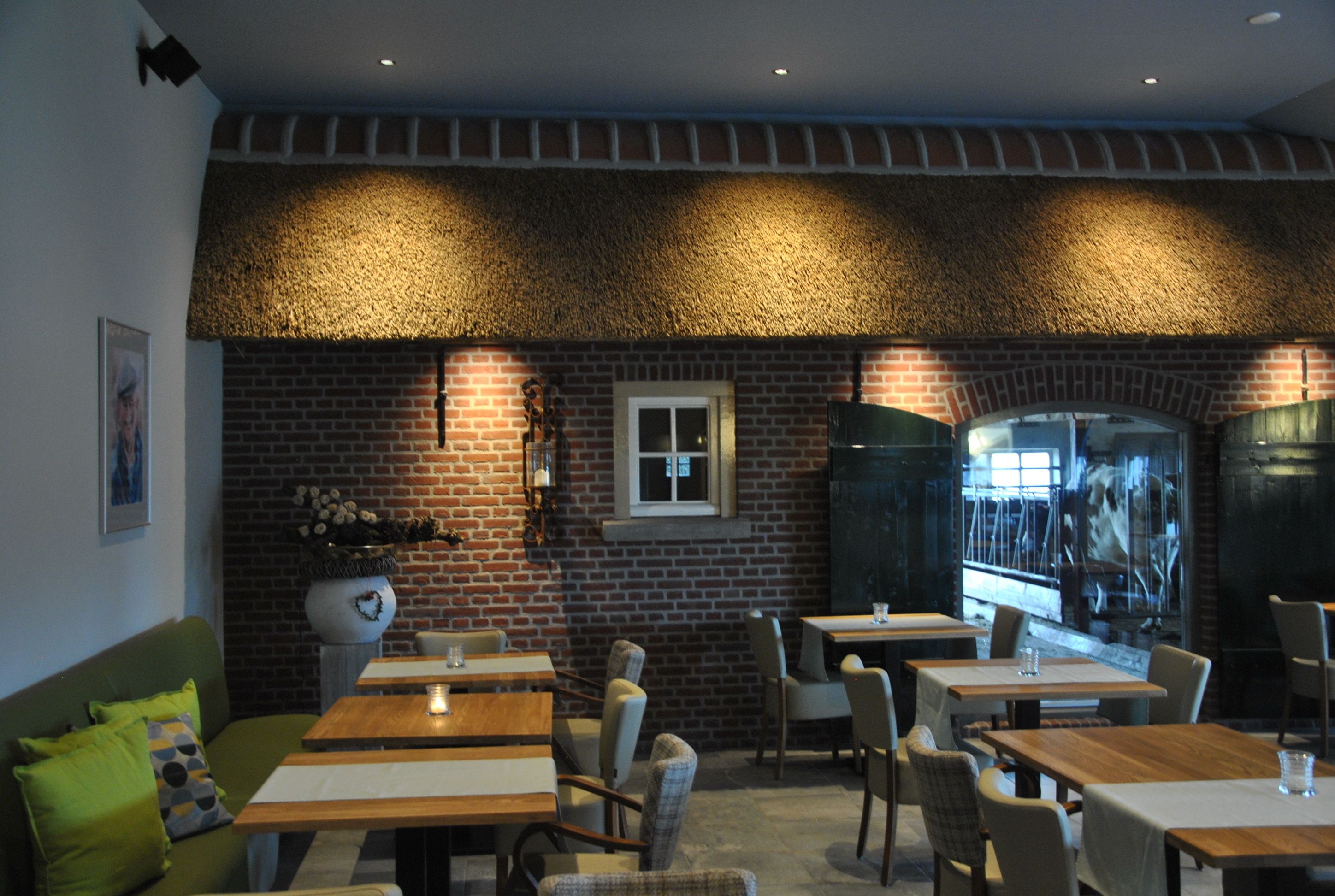 A restaurant with brick walls, wooden tables, and chairs.