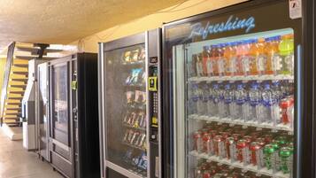 A row of vending machines with various beverages and snacks.