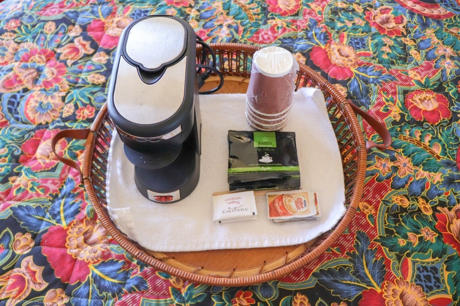 Une machine à café, une pile de dosettes de café et un paquet de café sur un plateau.