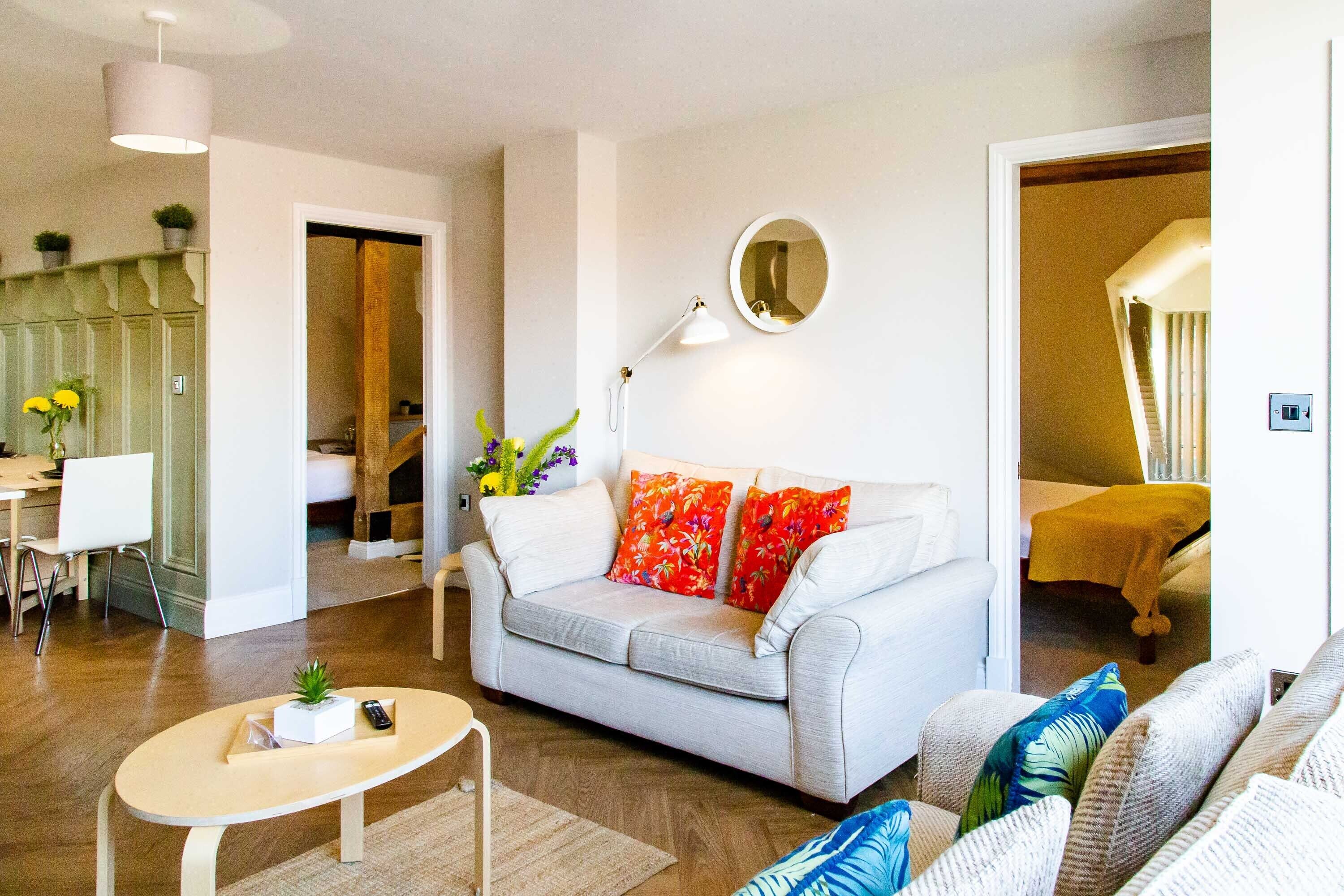 A modern living room with a sofa, a coffee table, and a dining area with a table and chairs.