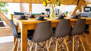 A dining area with a wooden table set for six, surrounded by chairs with metal legs. - Goodramgate Apartments (York)