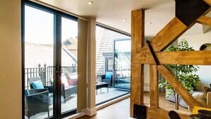 A spacious room with a large sliding glass door leading to an outdoor patio area. - Goodramgate Apartments (York)