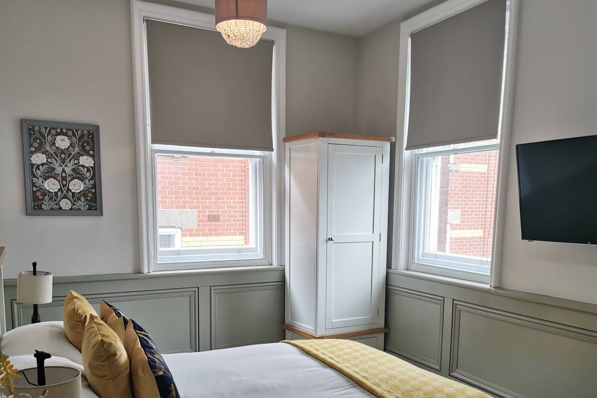 Une chambre à coucher avec un lit, une table de chevet, une lampe et un tableau au mur.