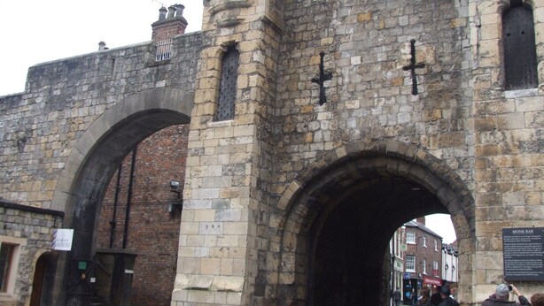 A historic stone archway with a sign for 'Monk Bar' visible in the background. - Goodramgate Apartments (York)