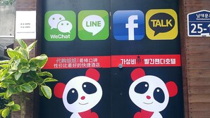 A Red Panda Hotel entrance with a signboard displaying WeChat, LINE, Facebook, and TALK logos, and a large panda graphic. - Seoul Central Hotel (Seoul)