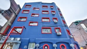 A multi-story building with red-framed windows and air conditioning units. - Seoul Central Hotel (Seoul)