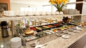 Un buffet proposant une variété de plats, d’assiettes et de couverts.