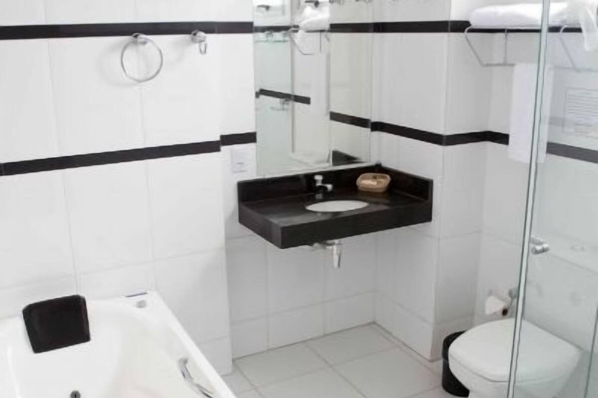 A modern bathroom with a bathtub, a glass shower enclosure, and a toilet.