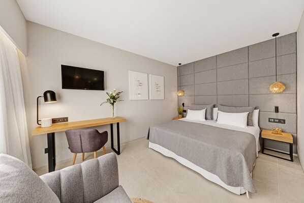Une chambre à coucher moderne avec un lit, un bureau, une chaise et un téléviseur.
