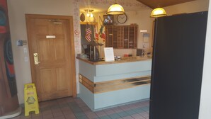 A reception area with a wooden door, a clock, and a sign indicating 'Employees Only'.