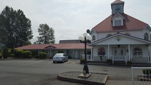 A motel with a red roof, a white facade, and a sign reading "Rainbow Motel Inn".