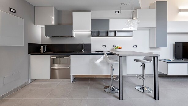 A modern kitchen with a central island, stainless steel appliances, and a minimalist design. - Experience Design Bed & Show (Milan)