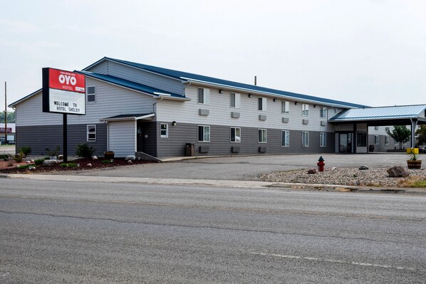 A hotel with a sign reading "OYO Hotel Shelby" and a covered parking area.